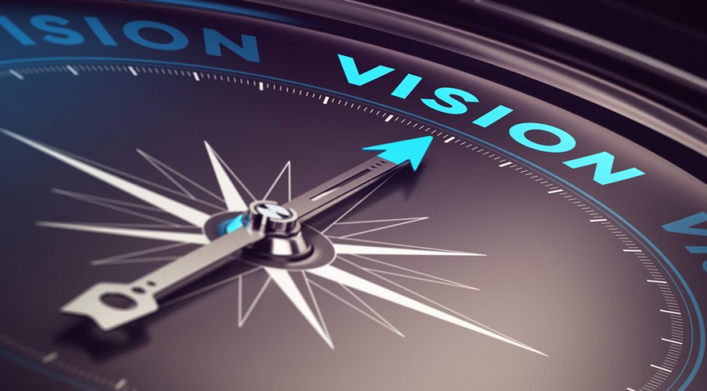 Compass with needle pointing the word vision with blur effect plus blue and black tones. Conceptual image for immustration of company or business anticipation or strategy